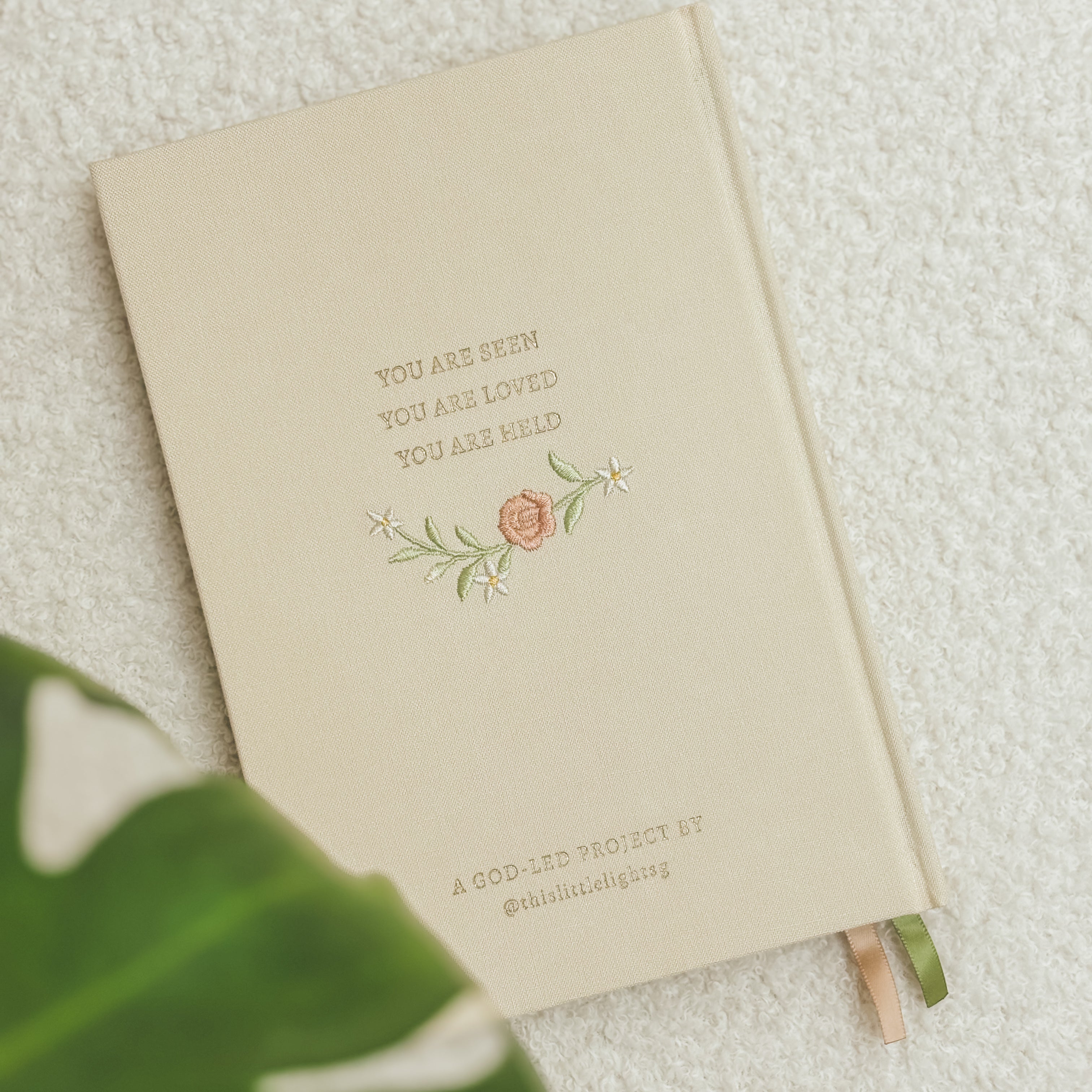 Back cover of This Little Light prayer journal with “You are seen, you are loved, you are held” text and floral embroidery