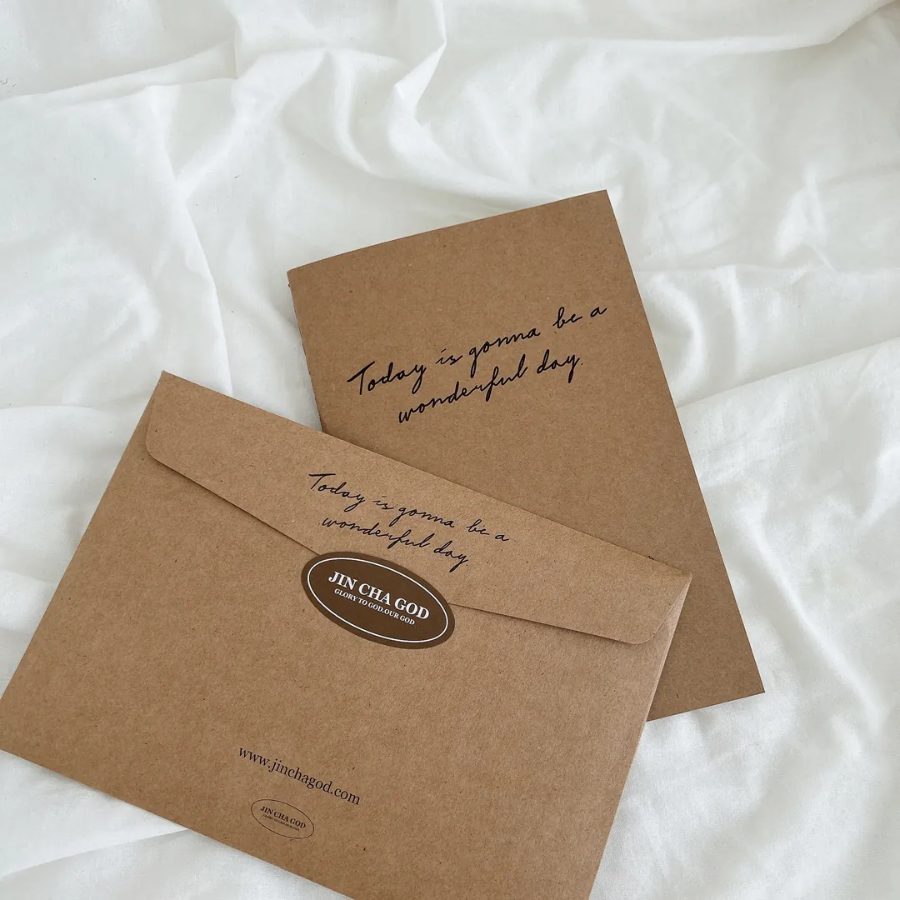 Today is gonna be a wonderful day A5 notebook and matching kraft envelope with inspirational message, displayed on a soft white fabric, encouraging simple happiness and positivity.