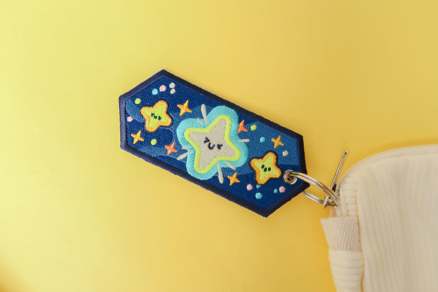 Detailed view of the reverse side of a motivational star-themed keychain.