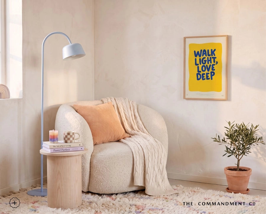 Walk Light Love Deep Christian poster framed above a cosy reading chair in a warm sunlit interior