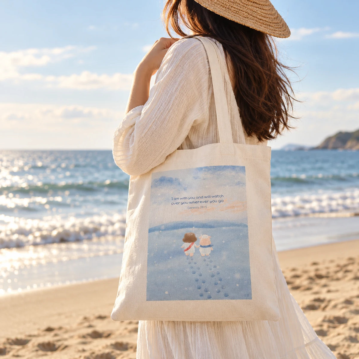 Woman carrying Watch Over You Christian tote bag with Genesis 28:15 artwork on a sunny beach