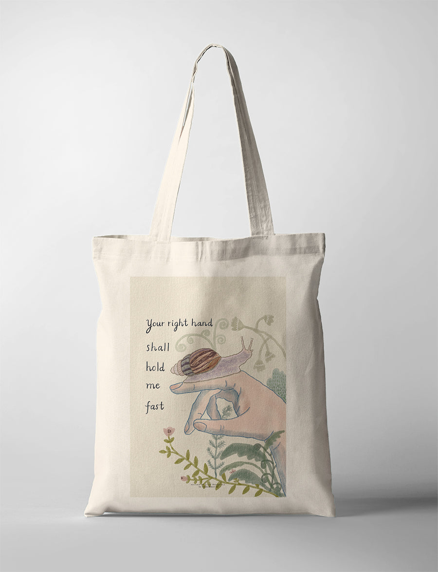 Christian tote bag featuring “Your right hand shall hold me fast” with a hand, snail, and botanical illustration