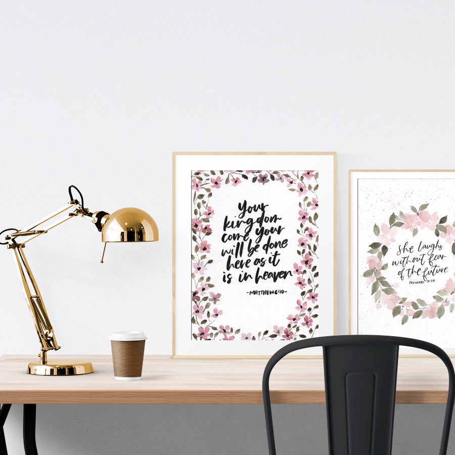 A3 beautiful calligraphy poster placed standing next to a smaller A4 sized calligraphy poster on a wooden table. Rustic Christian home interior design ideas.