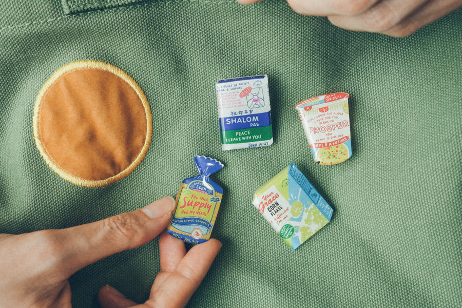Assorted pins makes plain canvas bag look pretty