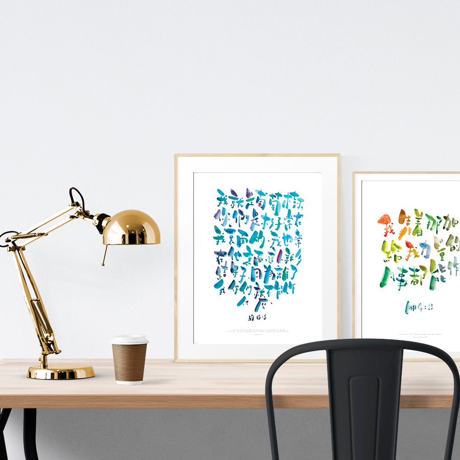 A3 beautiful calligraphy poster placed standing next to a smaller A4 sized calligraphy poster on a wooden table. Modern home interior design ideas.