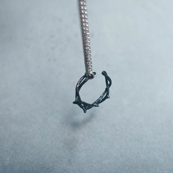 Black Gunmetal Crown of Thorns ring pendant on a long chain.