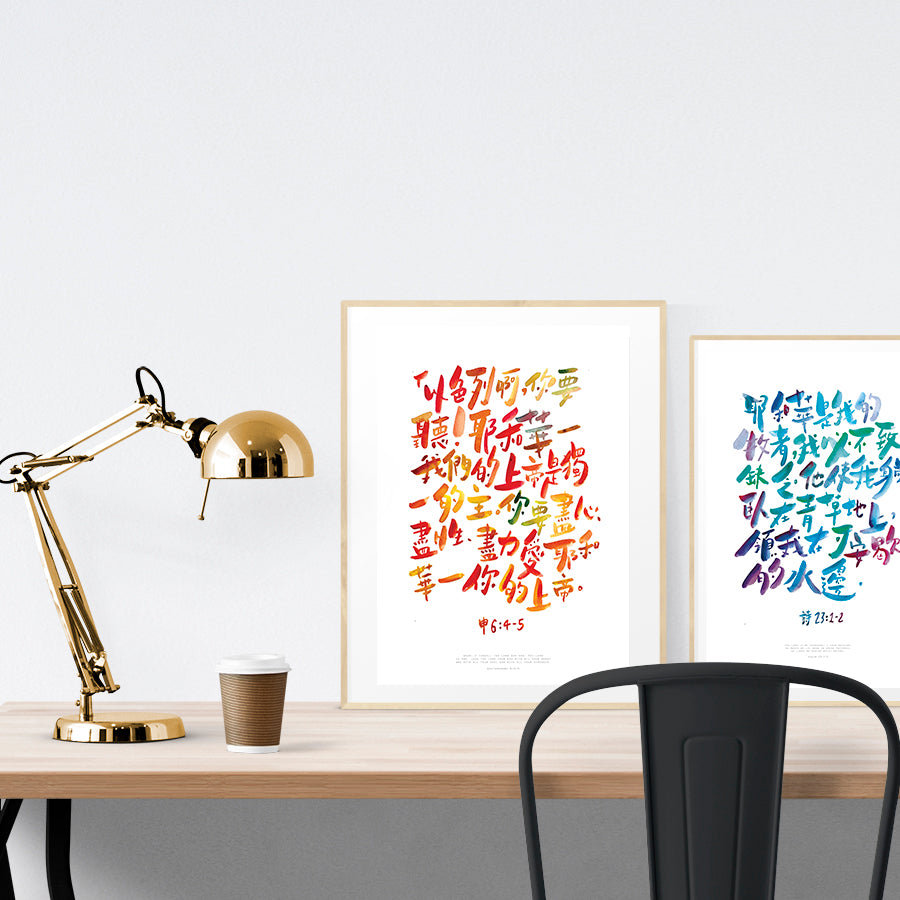 A3 beautiful calligraphy poster placed standing next to a smaller A4 sized calligraphy poster on a wooden table. Modern home interior design ideas.