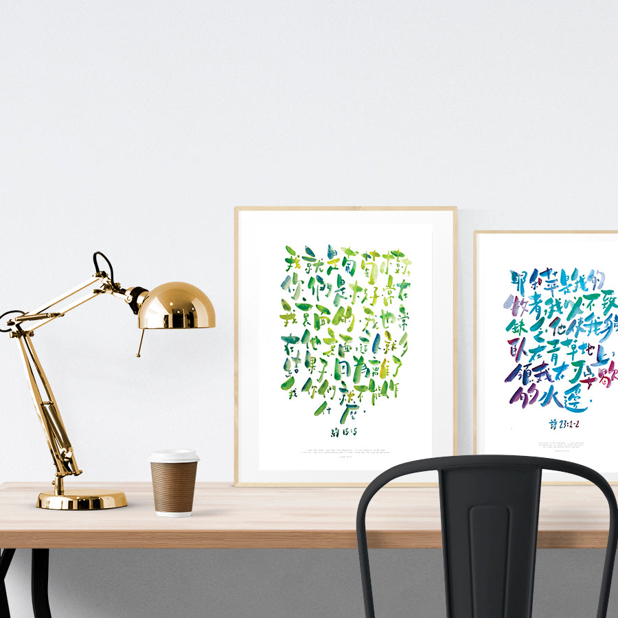 A3 beautiful calligraphy poster placed standing next to a smaller A4 sized calligraphy poster on a wooden table. Modern home interior design ideas.