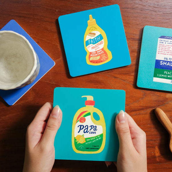 Love Supermarket wooden coaster assortment with playful Christian messages.
