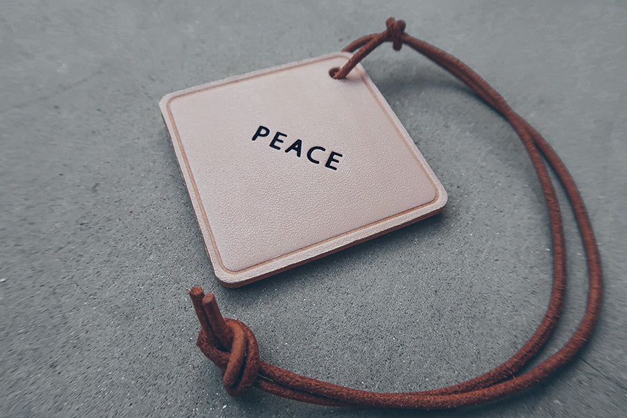 Minimalist Peace leather car charm product view.