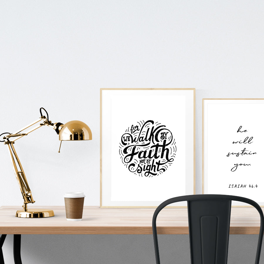 A3 beautiful calligraphy poster placed standing next to a smaller A4 sized calligraphy poster on a wooden table. Modern Christian home interior design ideas.