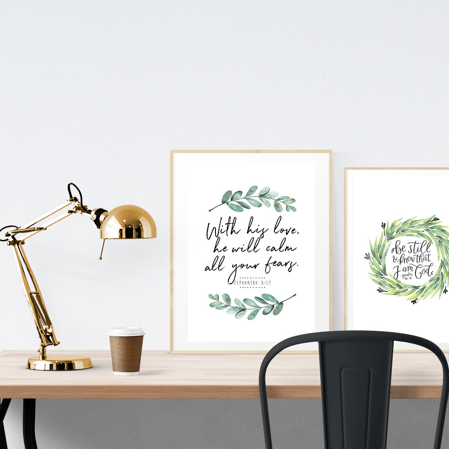 A3 beautiful calligraphy poster placed standing next to a smaller A4 sized calligraphy poster on a wooden table. Floral Christian home interior design ideas.