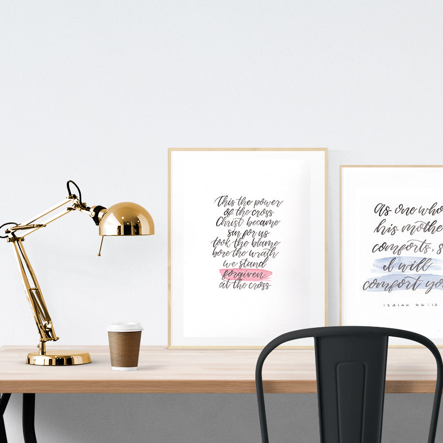 A3 beautiful calligraphy poster placed standing next to a smaller A4 sized calligraphy poster on a wooden table. Modern home interior design ideas.