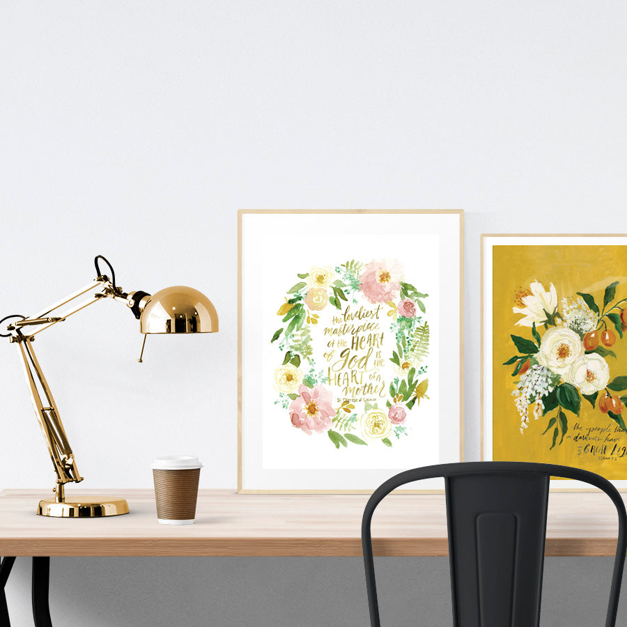 A3 beautiful calligraphy poster placed standing next to a smaller A4 sized calligraphy poster on a wooden table. Modern home interior design ideas. Rustic decor ideas