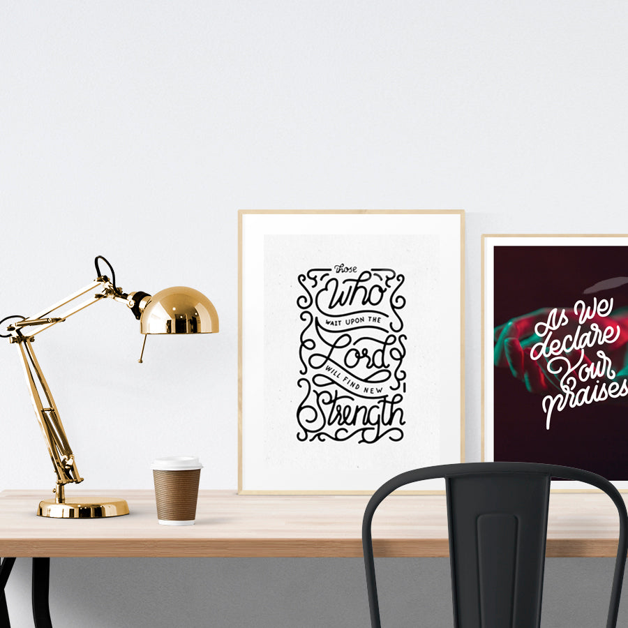 A3 beautiful calligraphy poster placed standing next to a smaller A4 sized calligraphy poster on a wooden table. Modern Christian home interior design ideas.