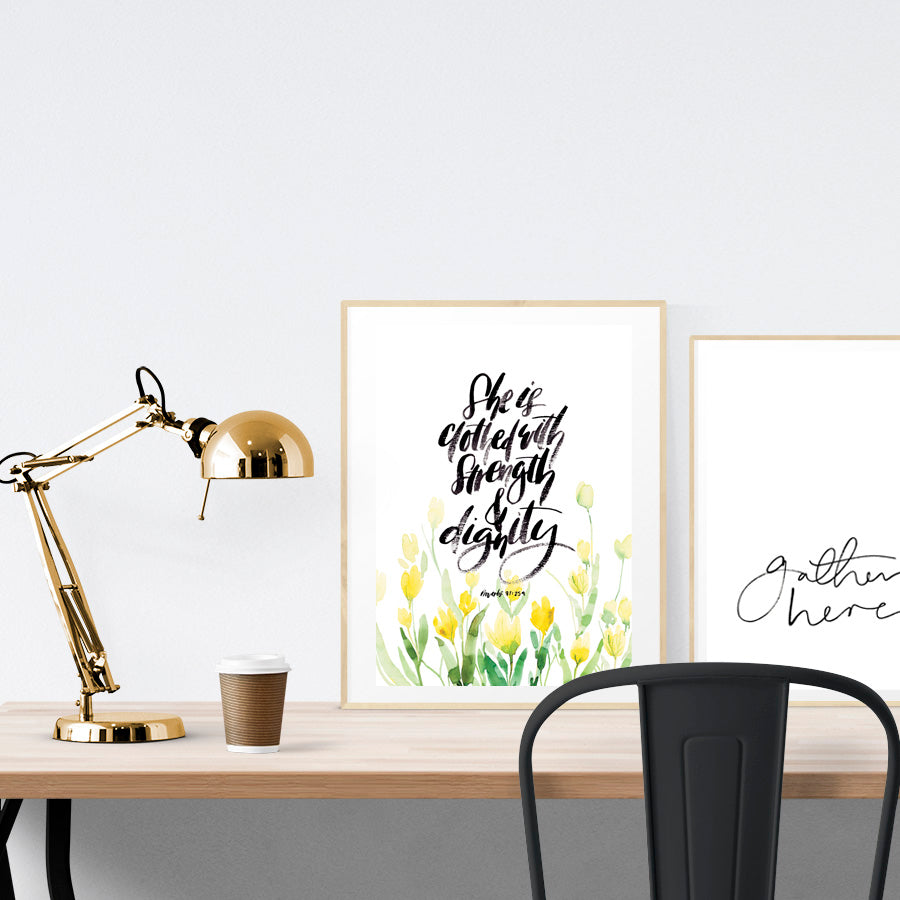A3 beautiful calligraphy poster placed standing next to a smaller A4 sized calligraphy poster on a wooden table. Minimalistic home interior design ideas.