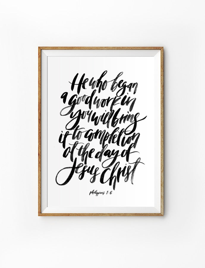 Poster featuring beautiful typography bible verses with water colour designs ‘He who began a good work in you will bring it to completion at the day of Jesus Christ’ is hung on the wall in a gold photo frame’. 200GSM paper, available in A3,A4 size.