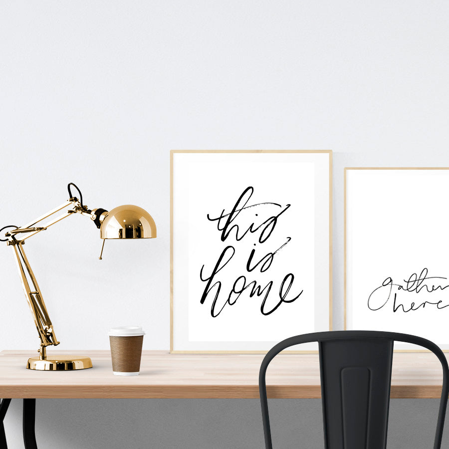 A3 beautiful calligraphy poster placed standing next to a smaller A4 sized calligraphy poster on a wooden table. Minimalistic home interior design ideas.