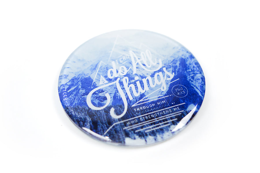 Close up of 5.5 cm diameter circular Acrylic fridge magnet with bible verse “I can do all things through Him who strengthens me” on mountains background.