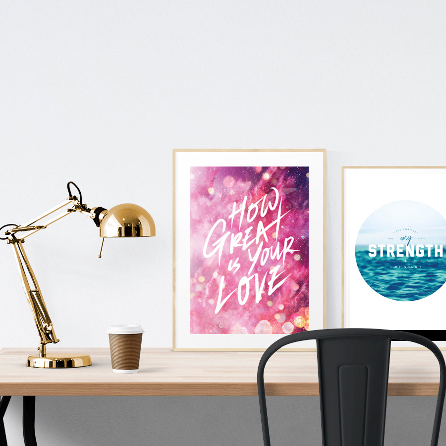 A3 beautiful calligraphy poster placed standing next to a smaller A4 sized calligraphy poster on a wooden table. Modern home interior design ideas.