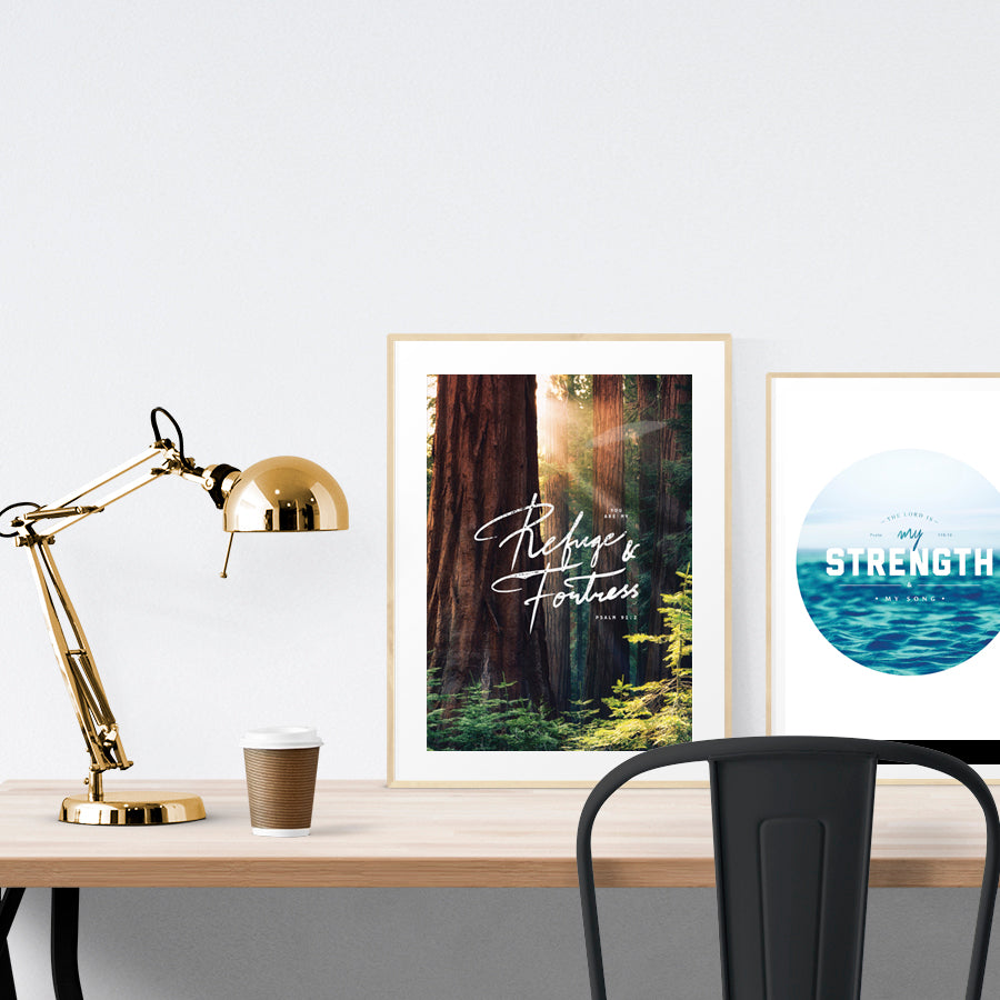 A3 beautiful calligraphy poster placed standing next to a smaller A4 sized calligraphy poster on a wooden table. Modern home interior design ideas.