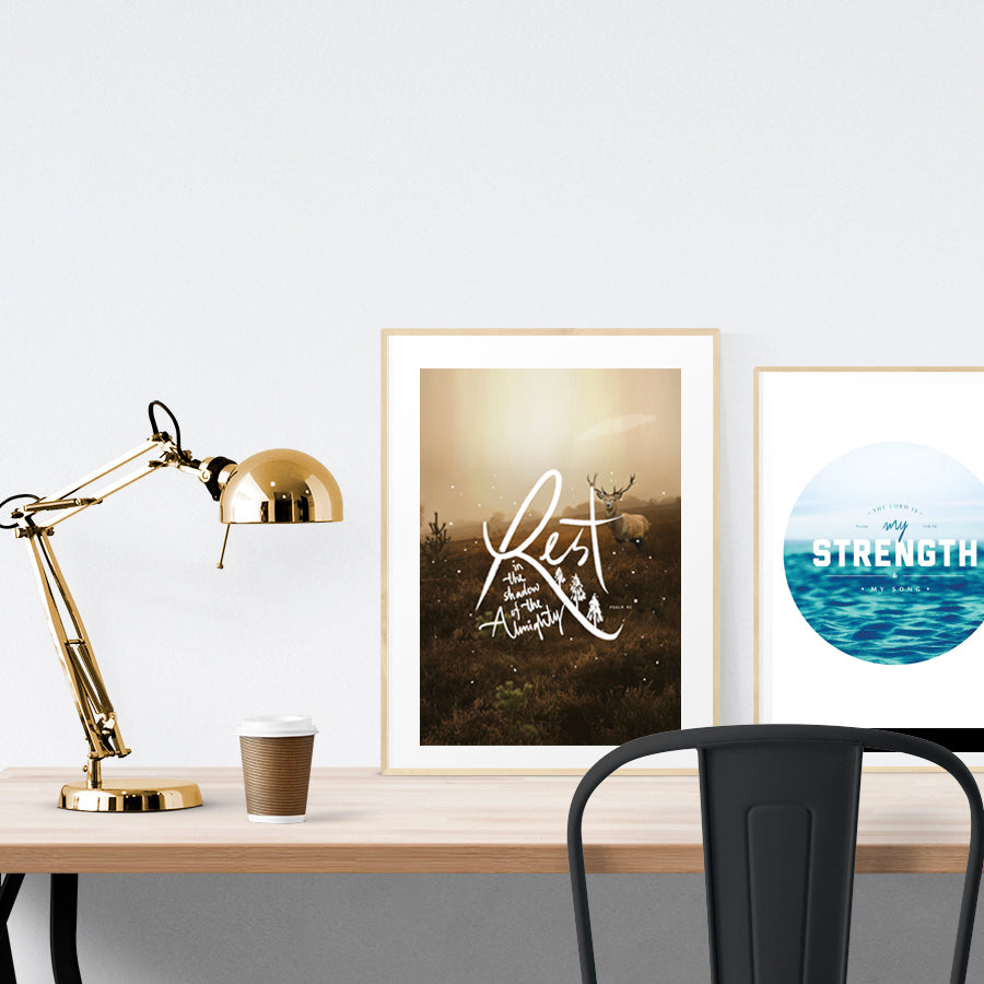 A3 beautiful calligraphy poster placed standing next to a smaller A4 sized calligraphy poster on a wooden table. Modern home interior design ideas.