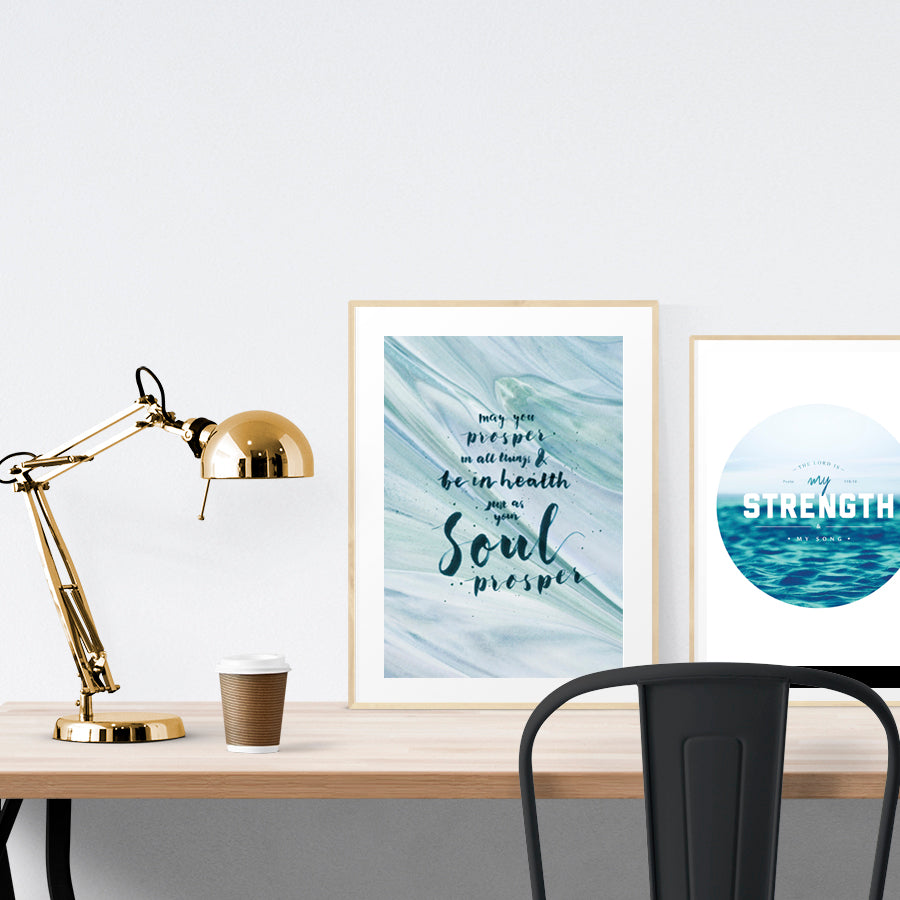 A3 beautiful calligraphy poster placed standing next to a smaller A4 sized calligraphy poster on a wooden table. Calm home interior design ideas.