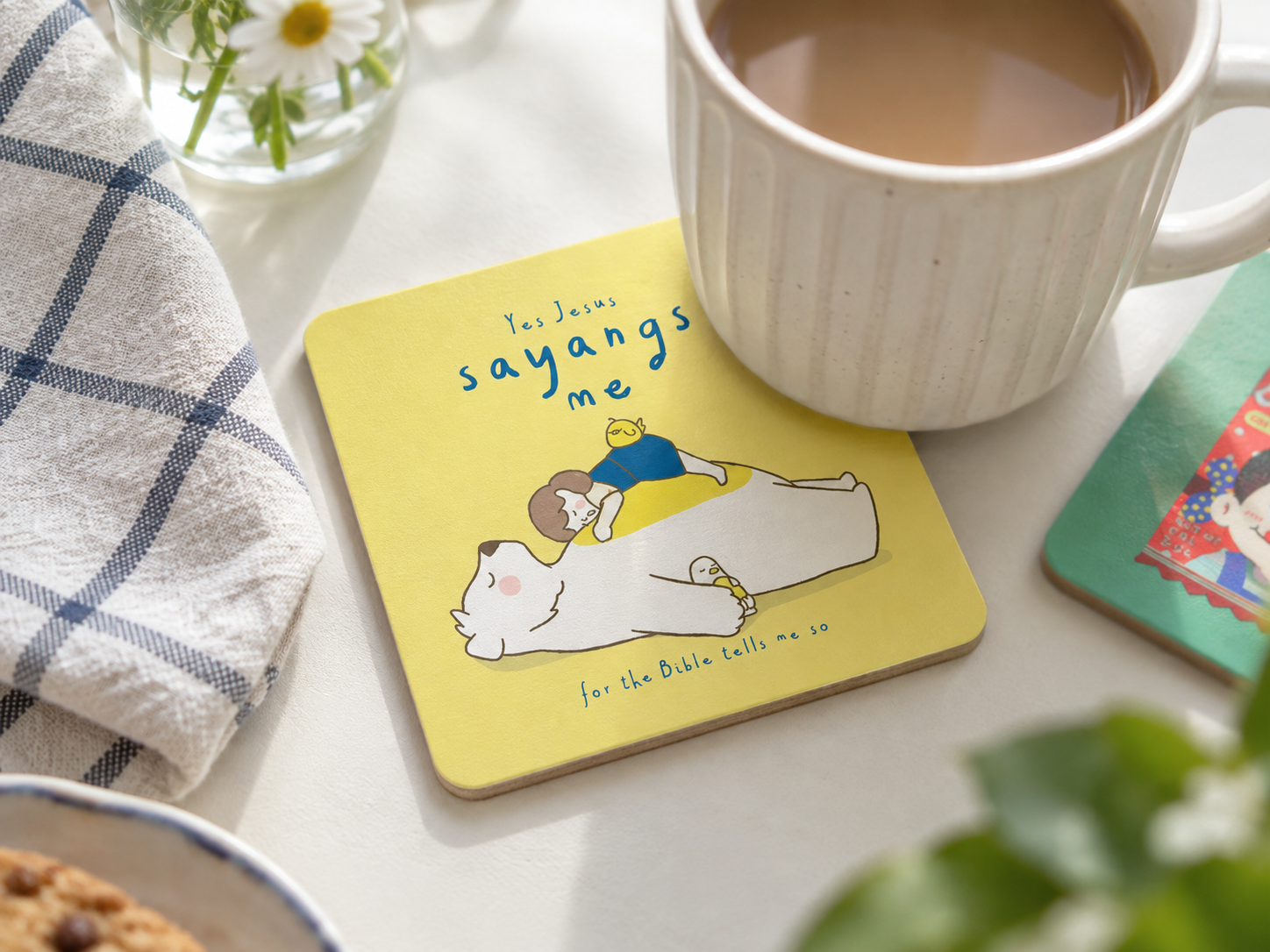 Yes Jesus Sayangs Me Christian wooden coaster with a coffee mug on a bright tabletop