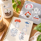 Vol. 1 Let God Cook Everyday Believer Christian stickers arranged on a notebook, laptop and bottle in a warm sunlit desk setting