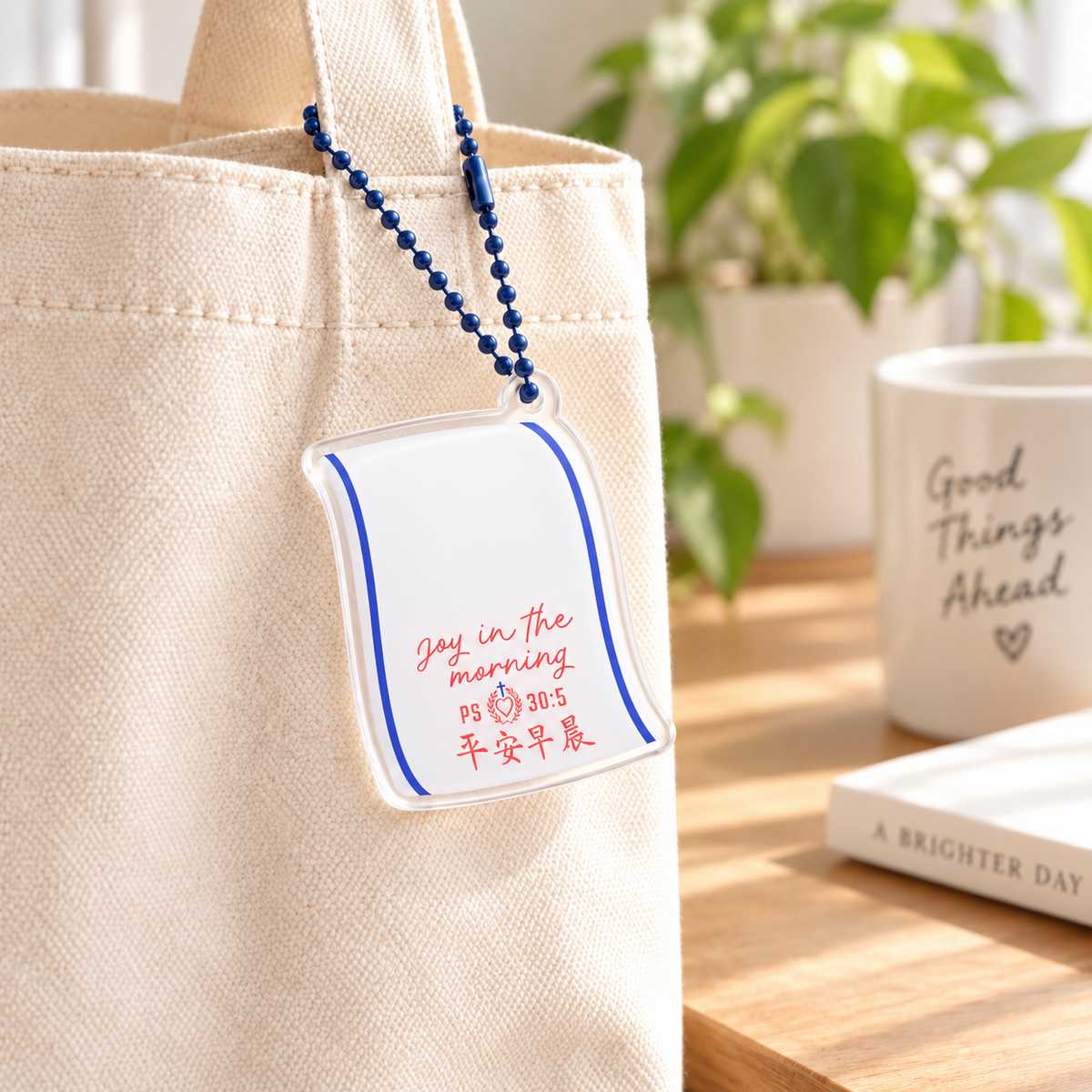 Good Morning Towel Joy in the Morning acrylic Christian keychain with blue ball chain wrapped around a canvas tote handle