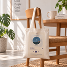 I Am Baptised customisable Christian song playlist tote bag hanging naturally from a wooden chair in a bright home interior