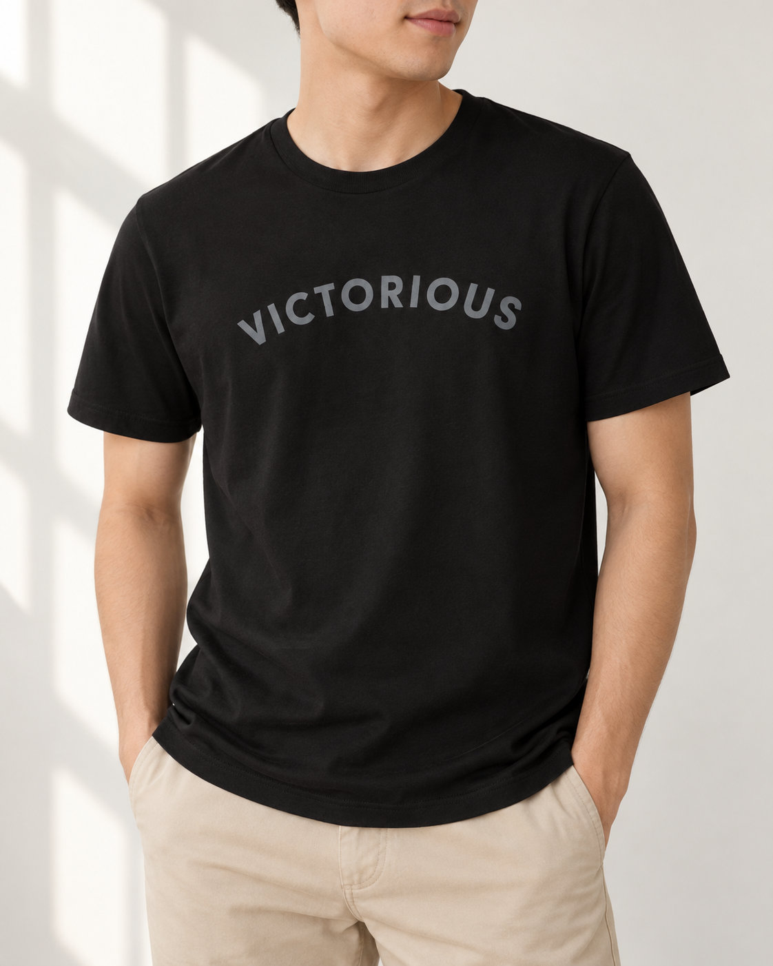 Victorious black Christian T-shirt worn casually in a bright minimalist interior