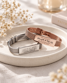 J&Co Foundry Classic Little Message Plate bracelets in silver and rose gold styled on a neutral ceramic tray