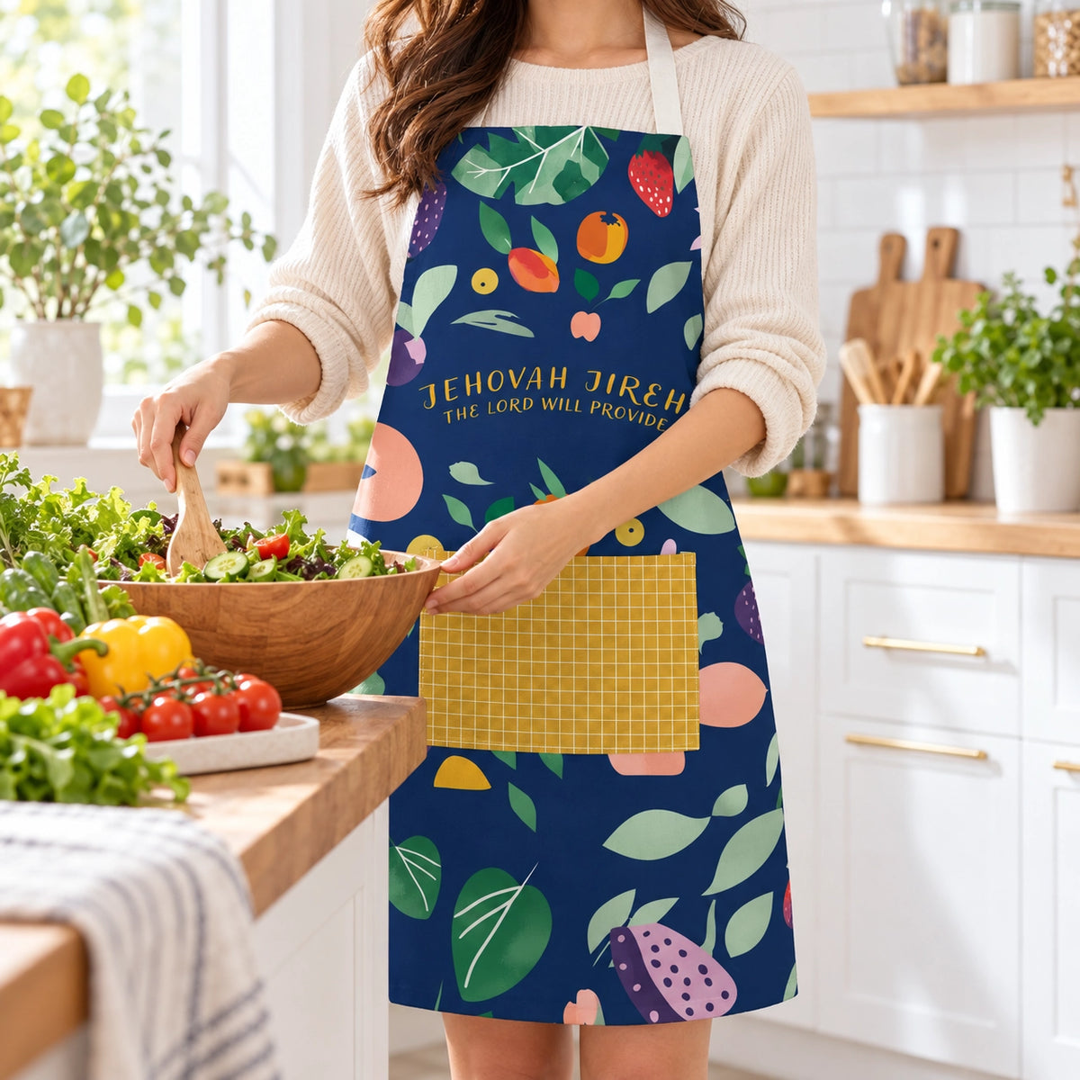 Jehovah Jireh The Lord Will Provide Christian apron worn while preparing a fresh salad in a bright modern kitchen