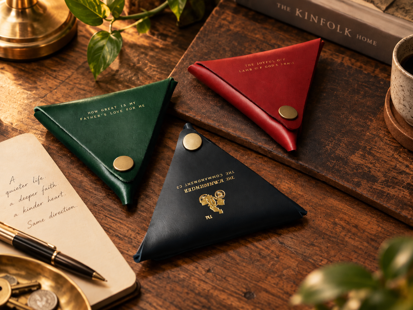 Leather coin pouches in vintage green, dark red and black styled on a warm wooden desk