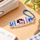 Beloved Little Lamb Sweet acrylic keychain styled on a warm wooden desk beside keys, a notebook and a cream pouch
