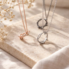 Crown of Thorns Christian necklaces in rose gold, silver and black finishes styled on a light stone surface with soft natural light