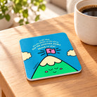 The Mountain Peaks Christian coaster with Psalm 95:4 on a warm wooden table beside coffee