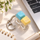 Enter His Rest two keycap keychain by laptop on a sunlit desk