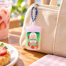 Taste and See matcha drink acrylic keychain on a beige canvas bag with a blue ball chain