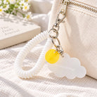 Trust God In All Things white cloud acrylic keychain with white spiral strap on a canvas bag