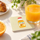 Fruit of the Spirit Orange Juice coaster beside a glass of orange juice