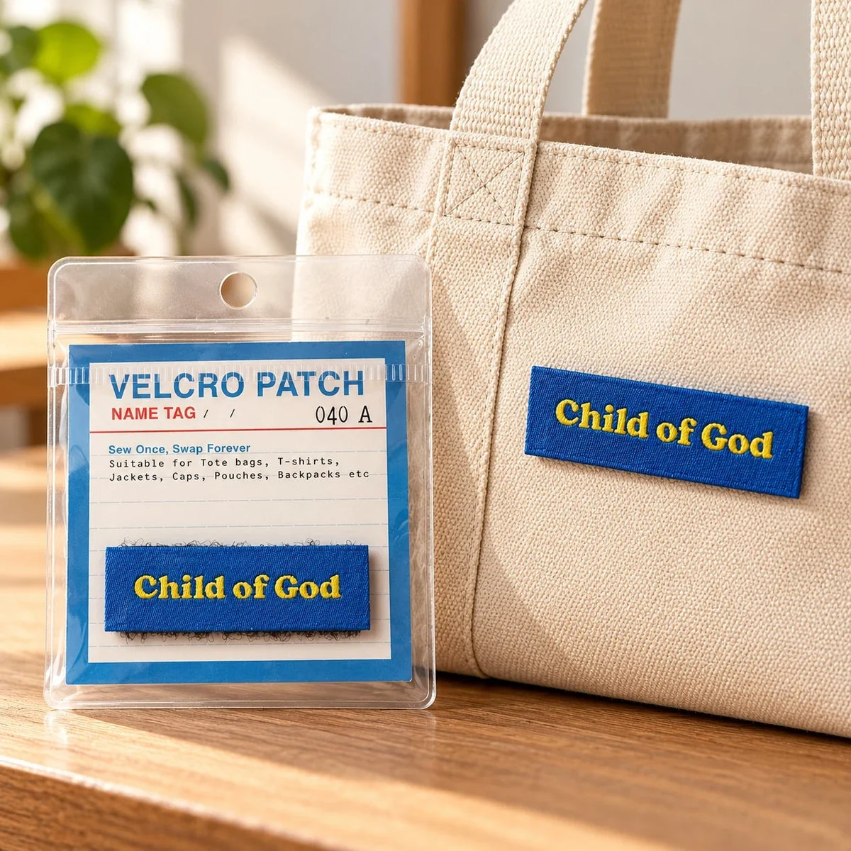 Child of God blue Velcro patch on a natural canvas tote bag beside its packaging