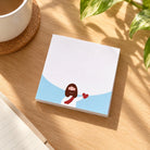 God Is Love sticky notes illustrated with Jesus on a sunlit wooden desk