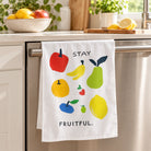 Stay Fruitful fruit-print tea towel hanging from a kitchen oven handle