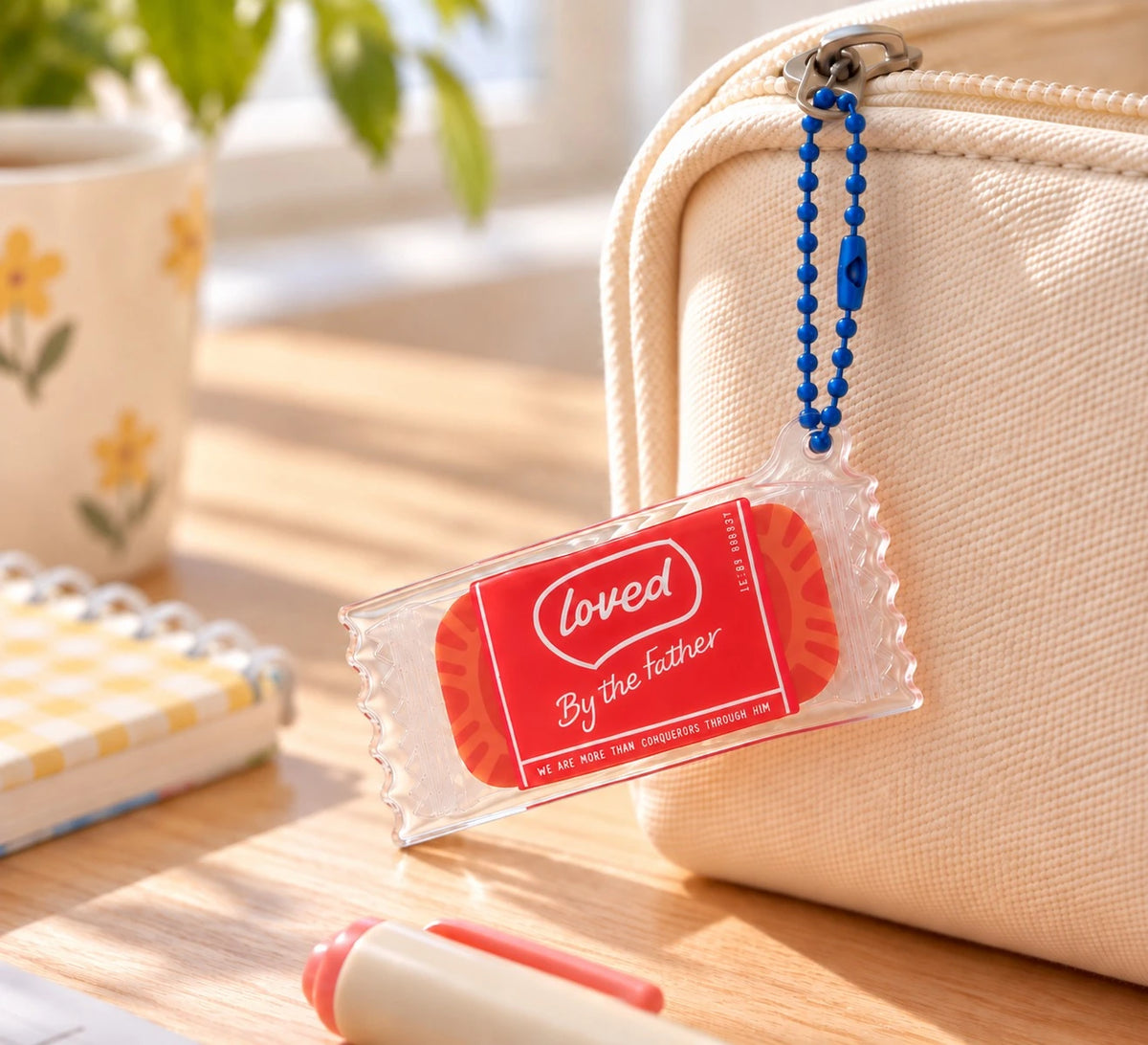 Loved by the Father coffee biscuit acrylic keychain hanging from a canvas bag