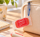 Loved by the Father coffee biscuit acrylic keychain hanging from a canvas bag