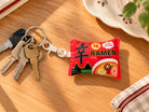 Xin Ramen plush keychain with keys on warm wood surface
