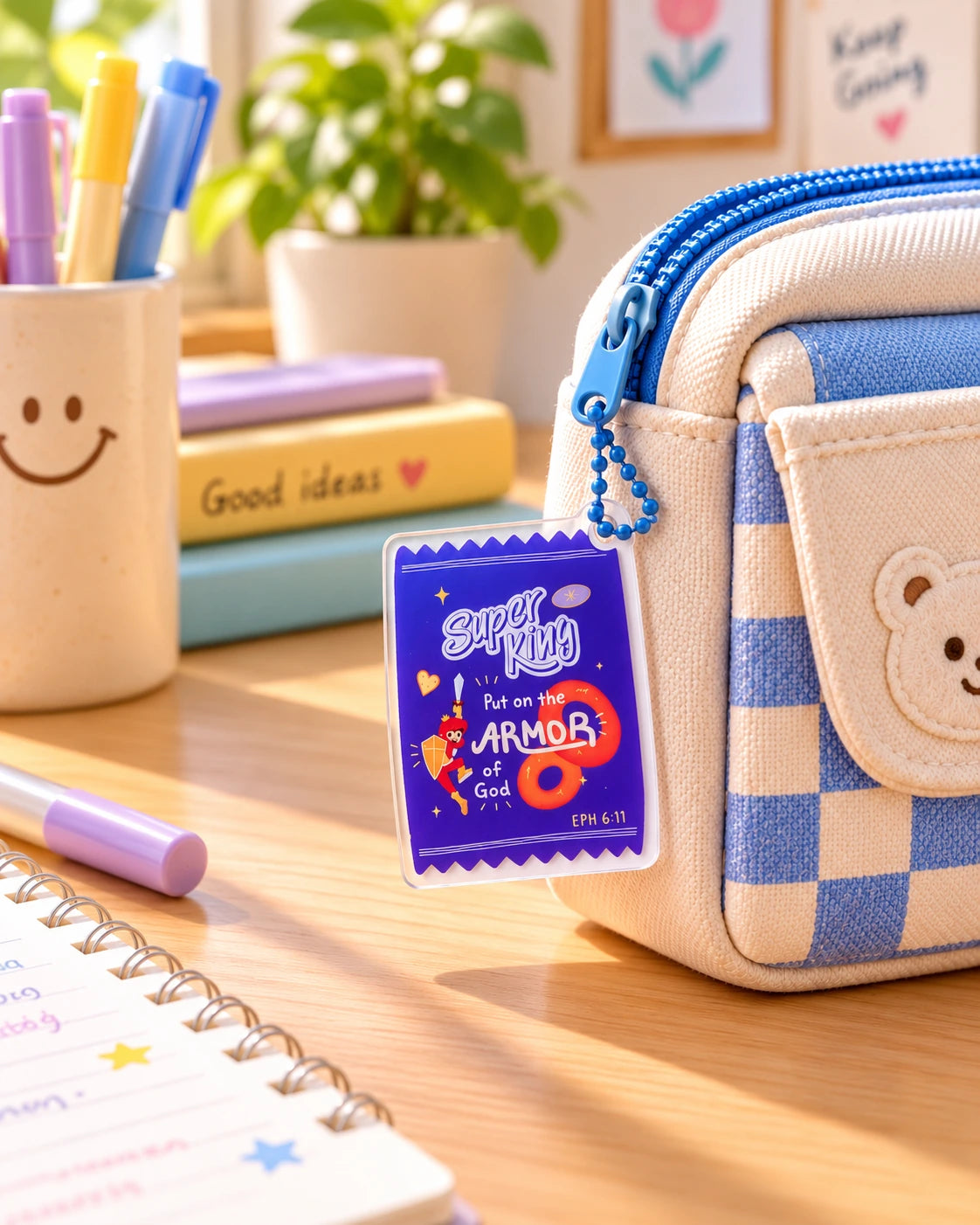 Super King Put on the Armour of God acrylic keychain hanging from blue checked pencil case