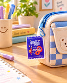 Super King Put on the Armour of God acrylic keychain hanging from blue checked pencil case